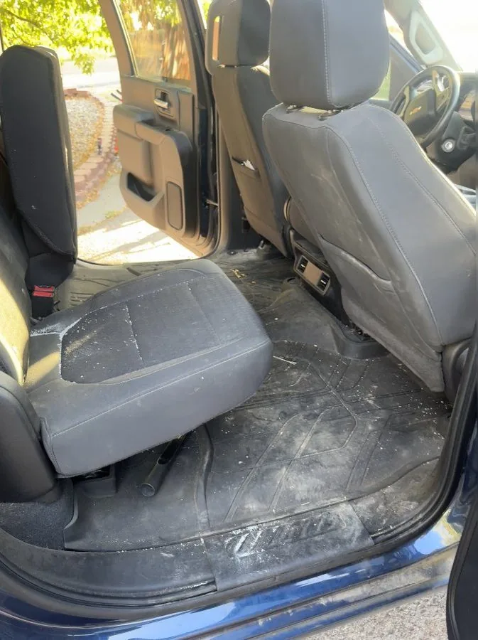 Chevy Silverado rear seats before interior detail in Idaho Falls — debris covering seats and mats