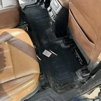 Midsize SUV floor before interior detail in Idaho Falls — dirt and debris